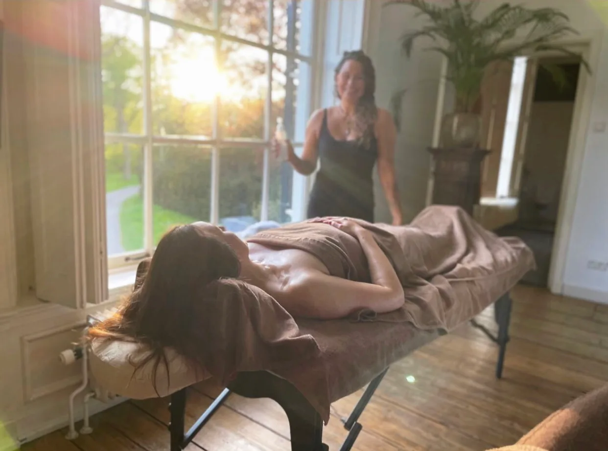 Een cliënt tijdens een rustige massagebehandeling van Amisha Glow